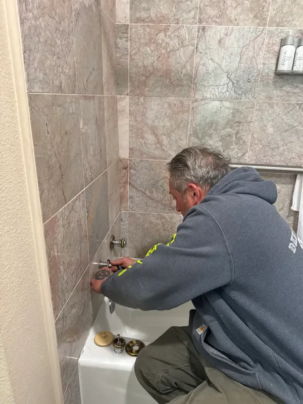 Brian Hoddick working on bathtub fixtures