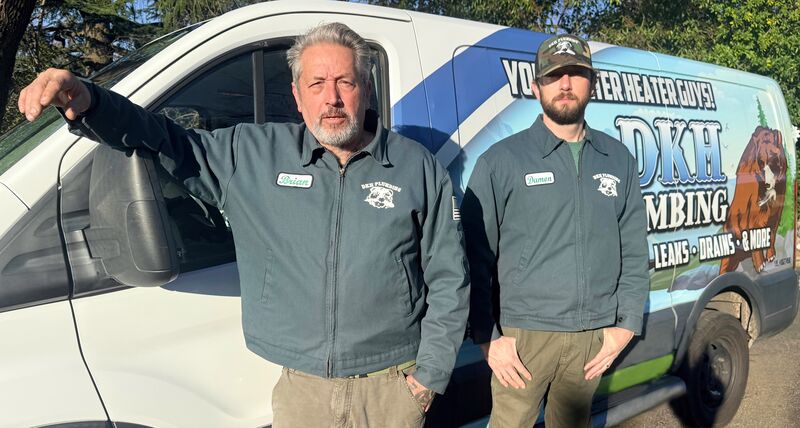 Brian and Damon from DKH Plumbing standing in front of their service van