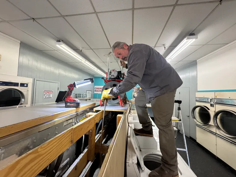Brian Hoddick using a drain machine for sewer line service