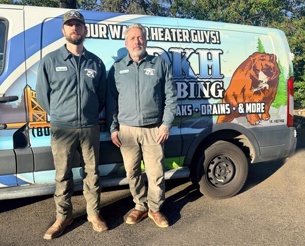 Damon and Brian from DKH Plumbing standing by their service van