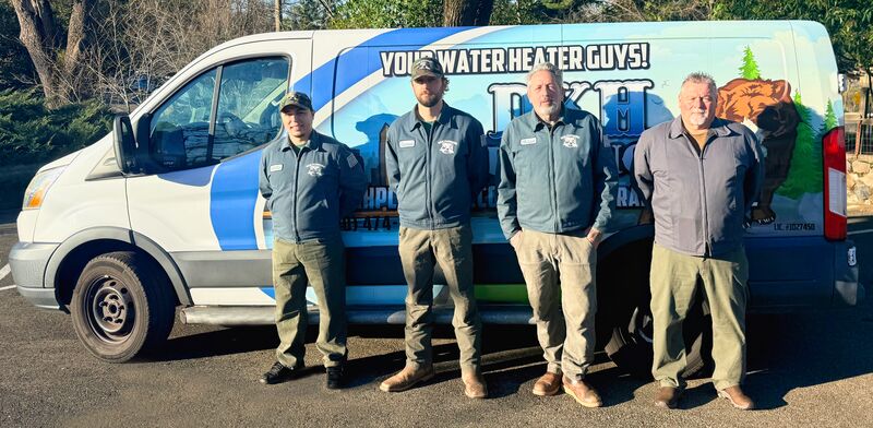 The DKH Plumbing team standing in front of their service van