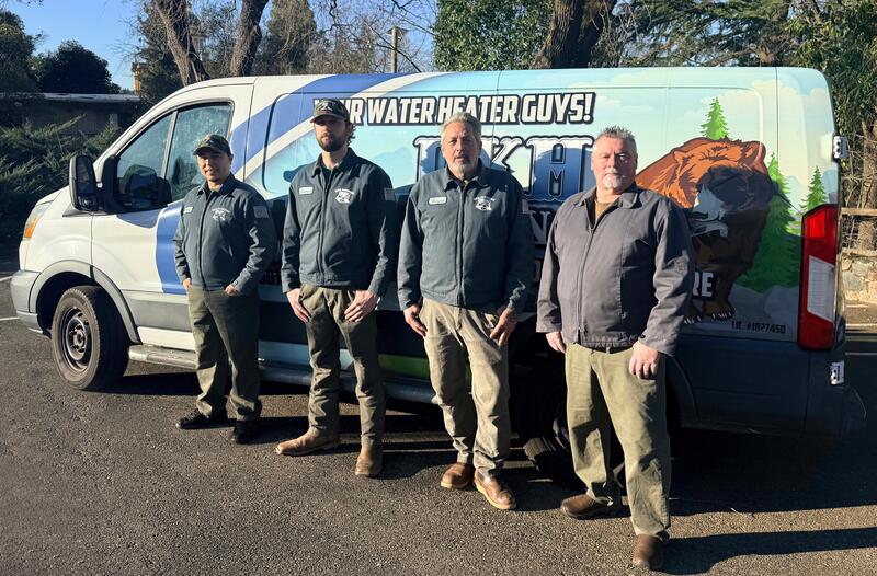 The DKH Plumbing team standing in front of their service van