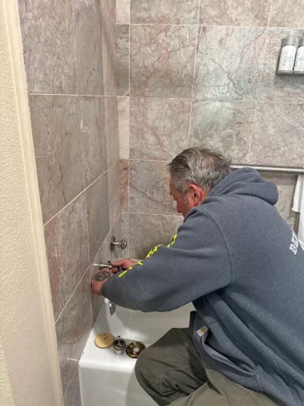 DKH Plumbing technician installing a bathtub fixture